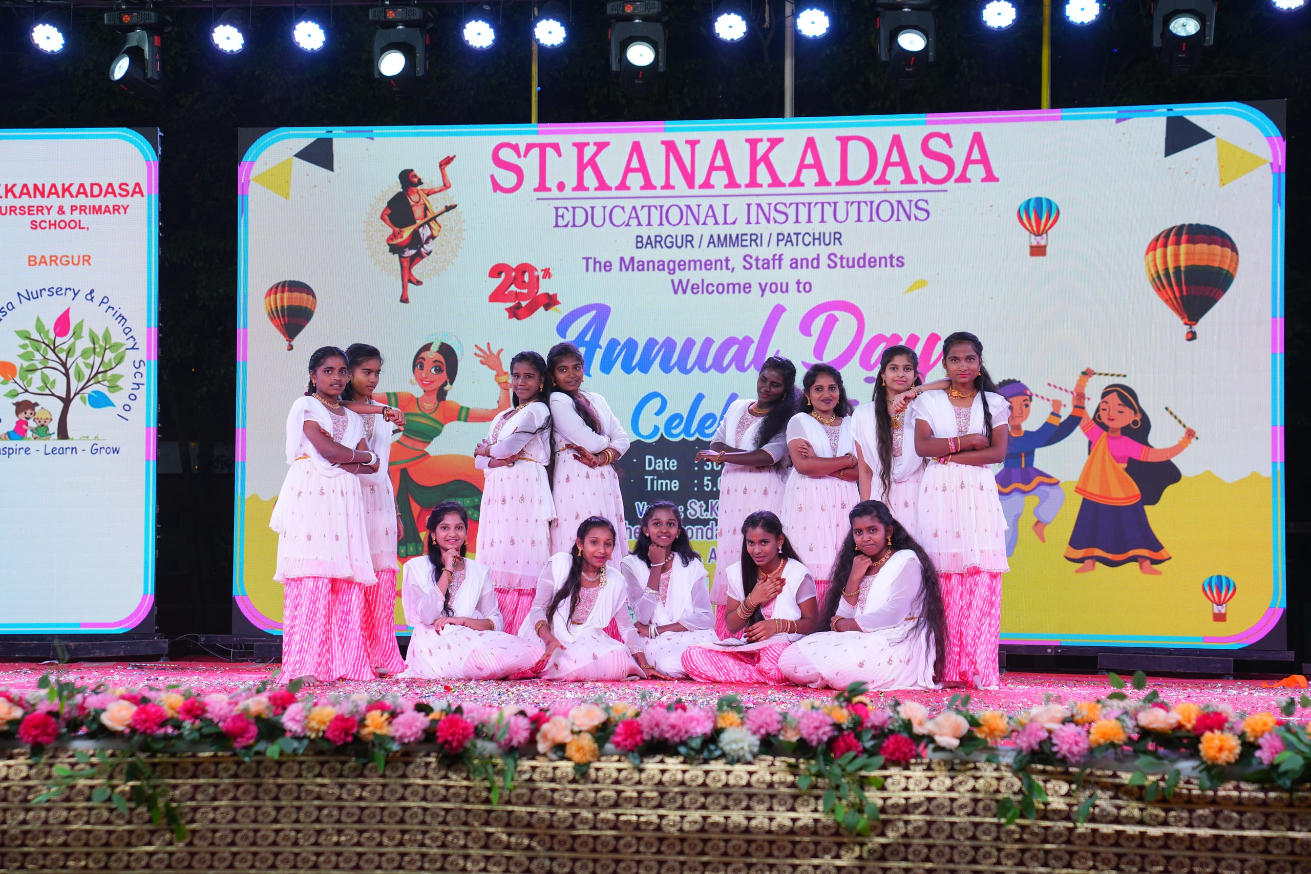 Students performing a group dance on stage during Annual Day