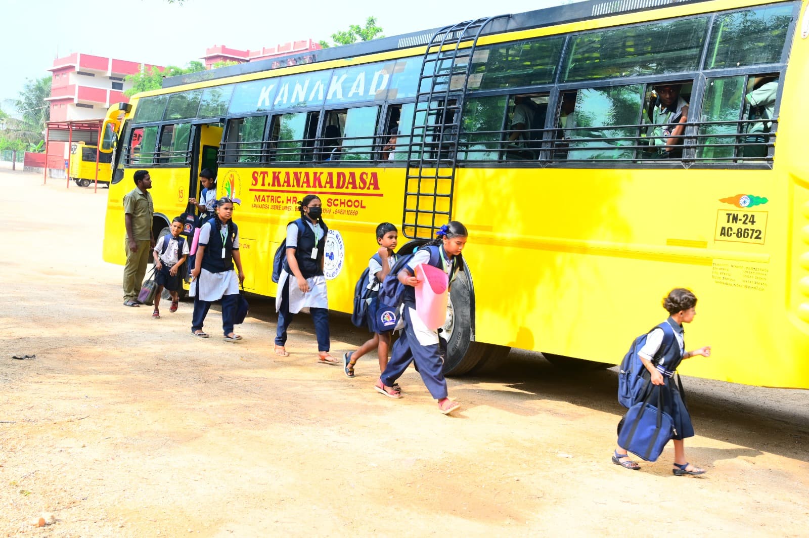 Students walking near a yellow school bus on campus
